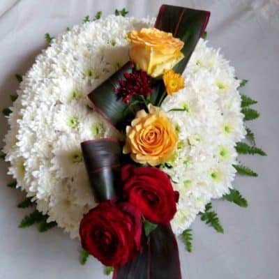 white circular wreath with red orange roses