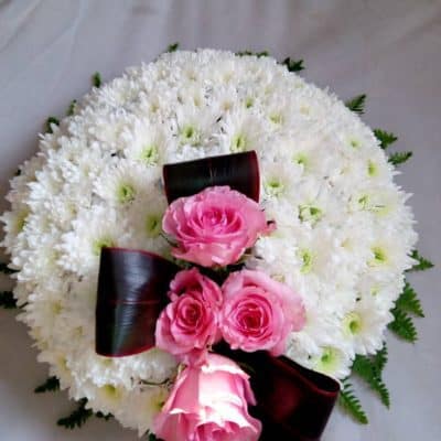 White circular wreath with pink rose spray